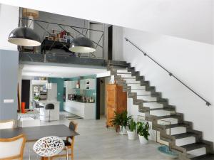 eine Treppe in einem Wohnzimmer mit einem Tisch und Stühlen in der Unterkunft Ref 111 Seignosse, Villa de standing 4 étoiles partiellement climatisée avec piscine chauffée et Wifi au calme sur terrain 1100m2 in Seignosse