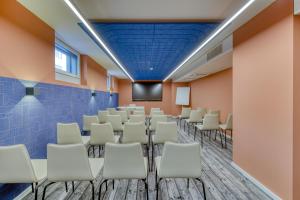 a conference room with chairs and a screen at ibis Styles Zurich City Center in Zurich