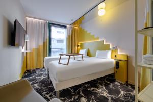 a hotel room with a bed and a table at ibis Styles Zurich City Center in Zurich +114 photos