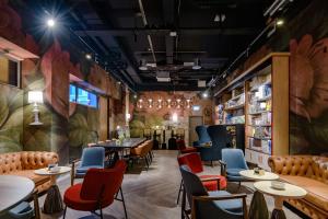 a restaurant with tables and chairs and a wall with plants at ibis Styles Zurich City Center in Zurich