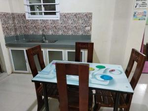 a kitchen with a table with two chairs and a kitchen counter at San Juan La Union Apartments in San Juan