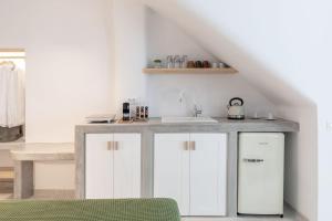 a white kitchen with a sink and a counter at Salvatore's Island House in Mýkonos City