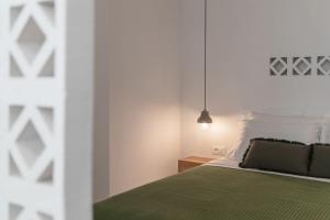 a bedroom with a green bed and a pendant light at Salvatore's Island House in Mýkonos City