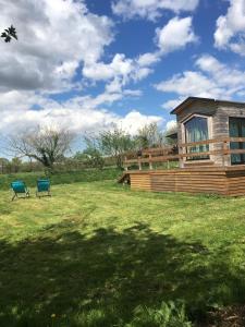 une maison avec deux chaises dans un champ dans l'établissement La Tiny Breizh, à La Poëtevinière