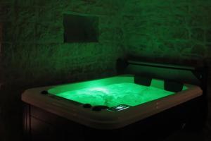 a green bath tub in a dark room at Albergo Diffuso Dimora Rossi in Turi