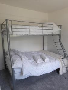 a bunk bed with white sheets and pillows on it at Nar river b&b in Kings Lynn