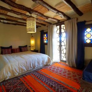 una camera da letto con un letto in una stanza con finestre di Riad Cafe Du Sud a Lac Yasmins
