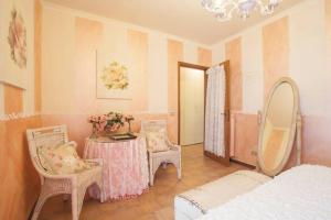 ein Schlafzimmer mit einem Tisch, Stühlen und einem Spiegel in der Unterkunft Relais De La Place in Desenzano del Garda