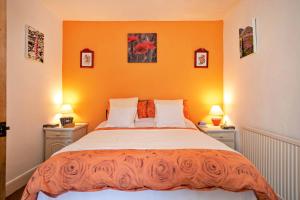 a bedroom with a large bed with orange walls at Finest Retreats - Sunny Bank in Grange Over Sands