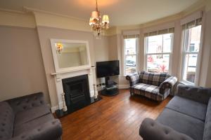 a living room with two couches and a fireplace at Luxurious Victorian Home by the sea - Myana House in Lowestoft