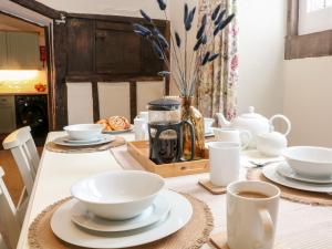 ein Tisch mit weißen Schalen und Tassen darauf in der Unterkunft Robin's Nest in Bakewell