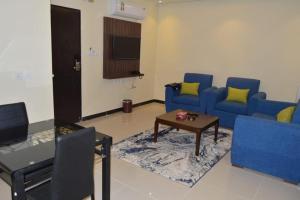 - un salon avec un canapé bleu et une table dans l'établissement فندق رذاذ, à Al Kharj
