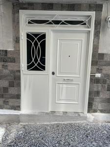 eine weiße Tür mit einem Fenster auf einem Backsteingebäude in der Unterkunft Cristiano room in Neapel