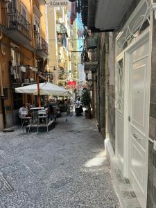 eine Gasse mit Tischen und Sonnenschirmen in einer Stadtstraße in der Unterkunft Cristiano room in Neapel