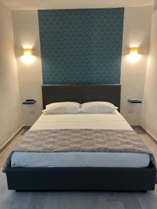 ein Schlafzimmer mit einem großen Bett mit blauer Wand in der Unterkunft Cristiano room in Neapel