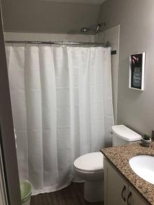 a bathroom with a toilet and a white shower curtain at Freshly Upgraded Cozy Loft @ North Creek Resort in Blue Mountains