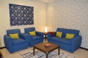 - un salon avec deux chaises bleues et une table dans l'établissement فندق رذاذ, à Al Kharj