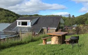 ein Haus mit einem Picknicktisch davor in der Unterkunft Abergwynant Farm Glamping & Apartments in Dolgellau