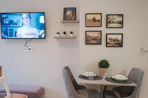 a living room with a table and a tv on a wall at Remvi in Komotini