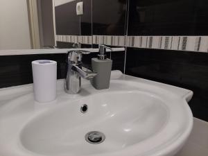 a white bathroom sink with two cups on it at Apartman Zrina Oštro in Kraljevica