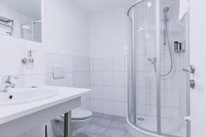 biała łazienka z prysznicem i umywalką w obiekcie Alpine City Living by we rent, SUMMERCARD INCLUDED w mieście Zell am See +37 zdjęć