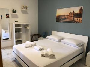 a bedroom with a white bed with towels on it at La Madonnina in Noto