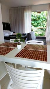 een woonkamer met een tafel en stoelen en een bank bij Villas do Pratagy Resort, Andar Superior in Maceió