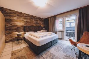 sypialnia z dużym łóżkiem i drewnianą ścianą w obiekcie Alpine City Living by we rent, SUMMERCARD INCLUDED w mieście Zell am See