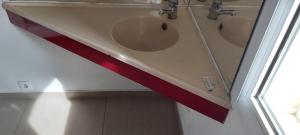 Un baño con dos lavabos con una cinta roja. en Hôtel Holiday Lyon Est en Saint-Pierre-de-Chandieu