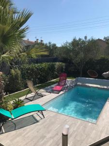 a swimming pool with two lawn chairs and a swimming pool at VILLA TRANQUILLE in Fréjus