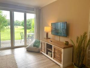 a living room with a flat screen tv on a wall at Rügen Westend - Wohnung 8 in Gingst