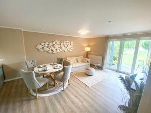 a living room with a table and chairs and a couch at Rügen Westend - Wohnung 8 in Gingst