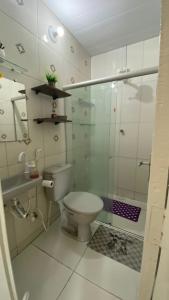 a bathroom with a toilet and a glass shower at Manancial Flats in Maragogi