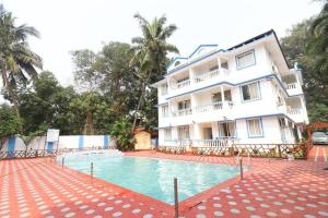 a building with a swimming pool in front of a building at Blue Lagoon Benaulim Goa in Marmagao