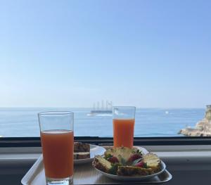 Dois pratos de comida e dois copos de sumo de laranja. em FRENNESIA Amalfi Coast em Atrani