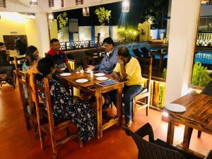 a group of people sitting at a table in a restaurant at Blue Lagoon Benaulim Goa in Marmagao