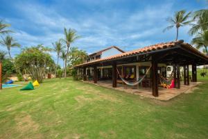 una casa con parque infantil en un patio en A Villa 8 suites 30 pessoas, en Cumbuco
