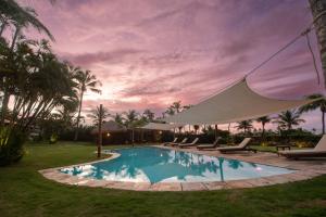 a swimming pool with lounge chairs and a tent around it at A Villa 8 suites 30 pessoas in Cumbuco