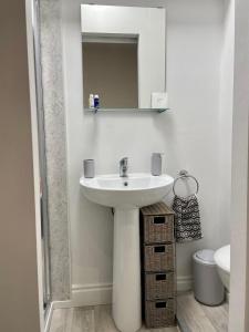 ein weißes Badezimmer mit einem Waschbecken und einem Spiegel in der Unterkunft Studio16 in Bristol