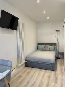 a bedroom with a bed and a flat screen tv at Studio16 in Bristol