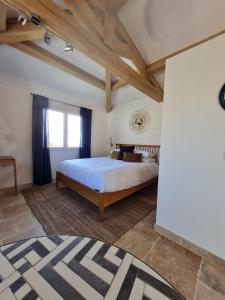 ein Schlafzimmer mit einem Bett und einem großen Fenster in der Unterkunft Adorable Maison Indépendante 30m2 avec Piscine en saison in Cabris