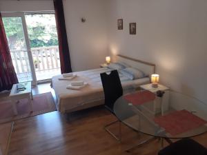 1 dormitorio con cama y mesa de cristal en Apartments Toni, en Mlini