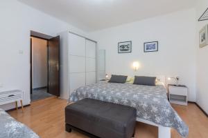 a bedroom with a bed and a ottoman at Apartment Luiza with Terrace in Baška