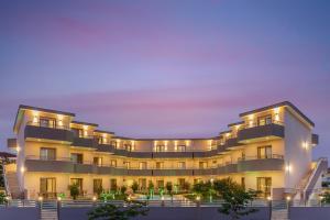 an exterior view of a building with lights at Aria Garden Suites in Nikiti