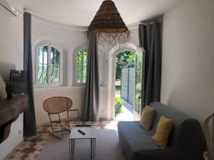 ein Wohnzimmer mit einem blauen Sofa und einem Tisch in der Unterkunft La Tour- Pigeonnier Provençal - Mas des Sous Bois in Ventabren