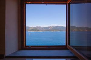 a window with a view of the water at La Suite del Faro - HelloElba in Portoferraio