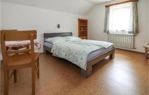 a bedroom with a bed and a chair and a window at Awesome Apartment In Obervellach With Wifi And 2 Bedrooms in Obervellach