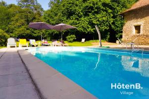 una piscina con sombrilla, mesas y sillas en Le château du Fraysseix à Roziers-Saint-Georges en Roziers-Saint-Georges