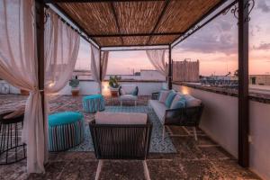 a patio with chairs and a couch on a balcony at Relais Palazzo Vaglio in Nardò