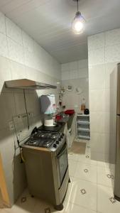 a small kitchen with a stove and a sink at Manancial Flats in Maragogi
